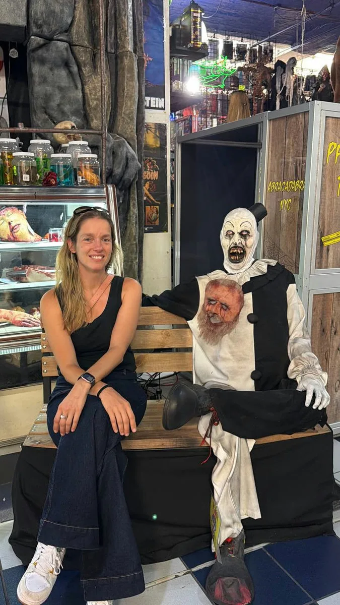 Stephanie sitting next to a spooky puppet inside Abracadabra, Manhattan