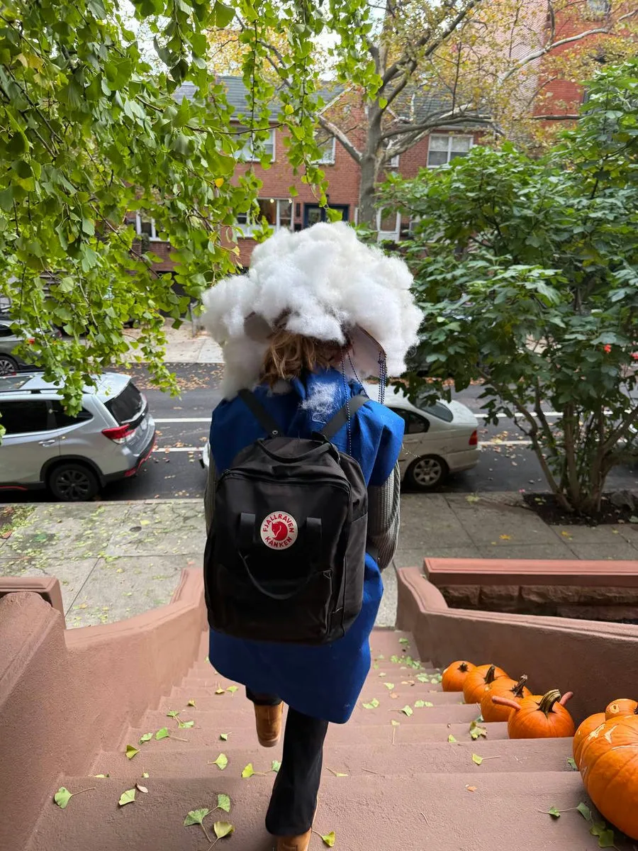 Stephanie's daughter in a little cloud costume walking up brownstone steps